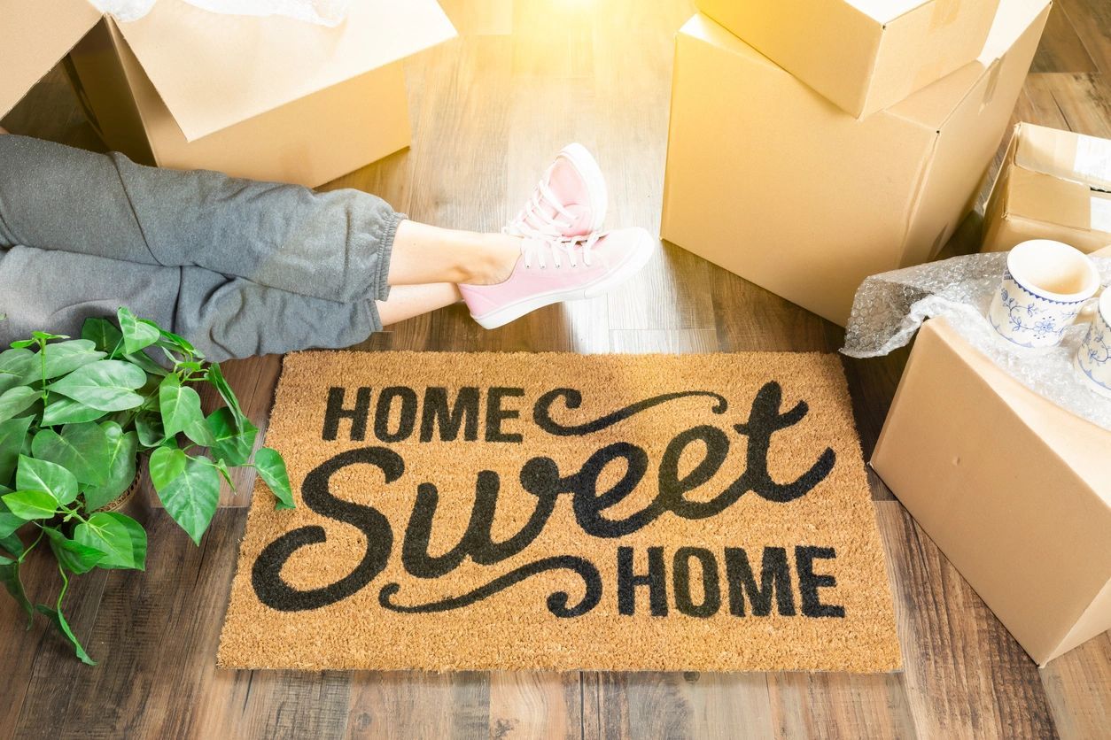 A person is opening boxes and holding onto some type of sign